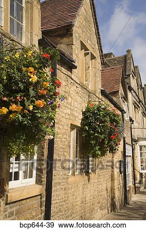 Stock Photo - Hanging flower boxes on stone buildings, Gloucestershire, United Kingdom. Fotosearch