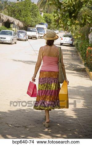 Hispanic woman carrying shopping bags View Large Photo Image Picture - Hispanic woman carrying shopping bags. Fotosearch