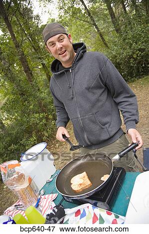 Man cooking outdoors View Large Photo Image Stock Photo - Man cooking outdoors. Fotosearch