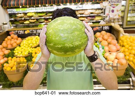 Man holding watermelon in supermarket View Large Photo Image Stock Image - Man holding watermelon in supermarket. Fotosearch