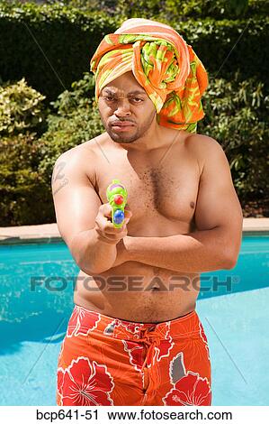 Man in towel turban pointing squirt gun View Large Photo Image Stock Image - Man in towel turban pointing squirt gun. Fotosearch