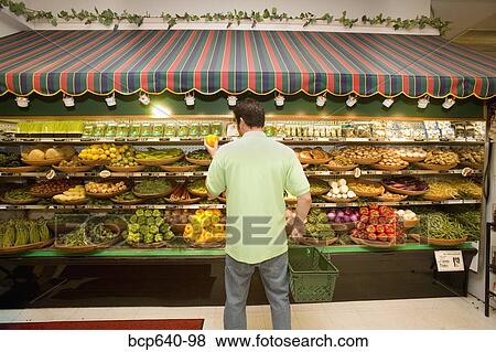 Man selecting produce in supermarket View Large Photo Image Stock Photo - Man selecting produce in supermarket. Fotosearch