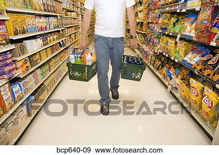 Man shopping in supermarket View Large Photo Image Stock Photo - Man shopping in supermarket. Fotosearch