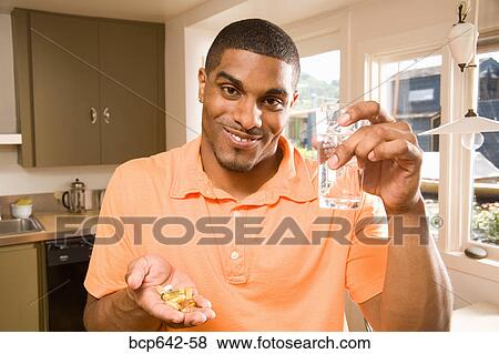 Stock Photo - Man taking a handful of pills. Fotosearch