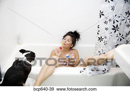 Stock Photo - Pacific Islander, Asian woman blowing bubbles out of bathtub. Fotosearch