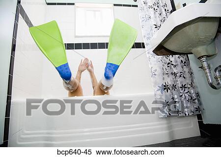 Stock Photography - Pacific Islander, Asian woman wearing flippers in bathtub. Fotosearch