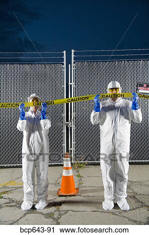 People in biohazard suits standing behind caution tape View Large Photo Image Stock Image - People in biohazard suits standing behind caution tape. Fotosearch
