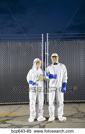 People in biohazard suits standing outside security gate View Large Photo Image Stock Photography - People in biohazard suits standing outside security gate. Fotosearch