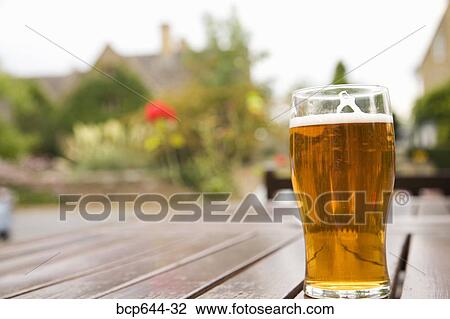 Pint of beer on outdoor table, Gloucestershire, United Kingdom View Large Photo Image Stock Image - Pint of beer on outdoor table, Gloucestershire, United Kingdom. Fotosearch