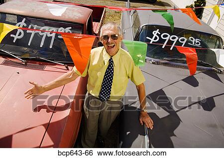 Stock Photograph - Used car salesman and cars. Fotosearch