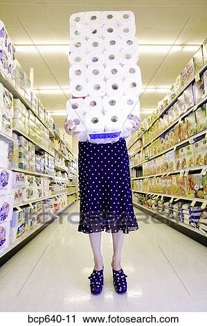 Woman carrying stack of toilet paper in supermarket View Large Photo Image Stock Image - Woman carrying stack of toilet paper in supermarket. Fotosearch