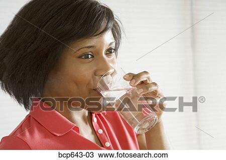 Woman drinking a glass of water View Large Photo Image Stock Image - Woman drinking a glass of water. Fotosearch