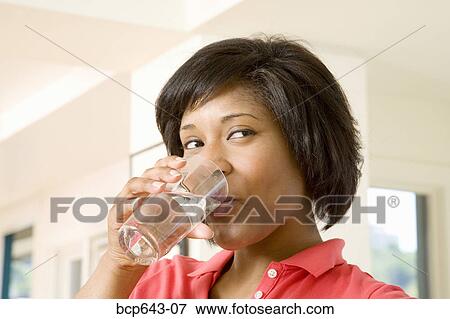 Woman drinking a glass of water View Large Photo Image Stock Photo - Woman drinking a glass of water. Fotosearch