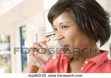 Woman drinking a glass of water View Large Photo Image Stock Photography - Woman drinking a glass of water. Fotosearch