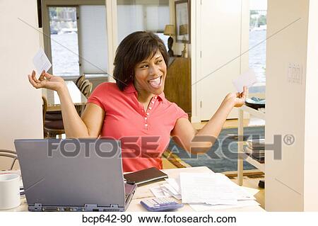 Stock Image - Woman happily tearing mail. Fotosearch