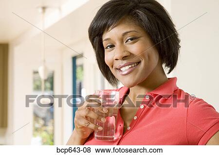 Woman having a glass of water View Large Photo Image Stock Photo - Woman having a glass of water. Fotosearch