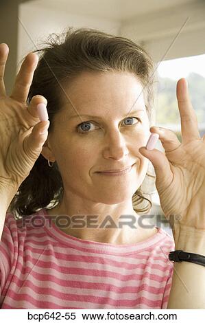 Stock Photography - Woman holding pills. Fotosearch