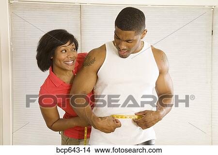 Woman measuring husband’s waist View Large Photo Image Picture - Woman measuring husband’s waist. Fotosearch