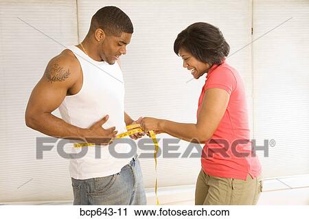 Woman measuring husband’s waist View Large Photo Image Stock Image - Woman measuring husband’s waist. Fotosearch