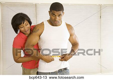 Woman measuring husband’s waist View Large Photo Image Stock Image - Woman measuring husband’s waist. Fotosearch