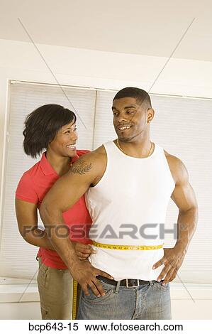 Woman measuring husband’s waist View Large Photo Image Stock Photography - Woman measuring husband’s waist. Fotosearch