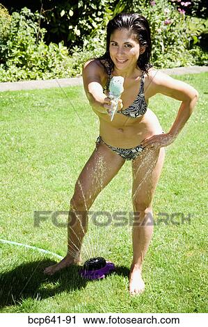 Woman offering ice cream in her backyard View Large Photo Image Stock Image - Woman offering ice cream in her backyard. Fotosearch