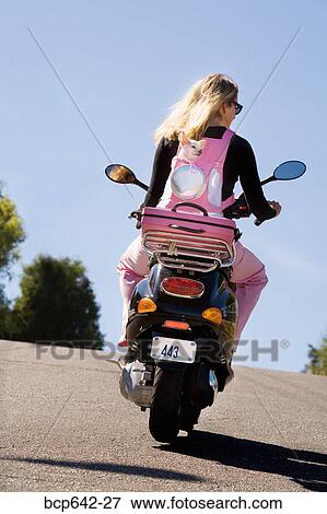 Woman riding a scooter View Large Photo Image Stock Photo - Woman riding a scooter. Fotosearch