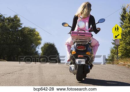 Woman riding a scooter View Large Photo Image Stock Photo - Woman riding a scooter. Fotosearch
