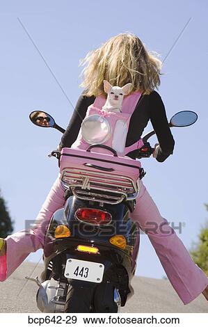 Woman riding a scooter with extended legs View Large Photo Image Stock Photo - Woman riding a scooter with extended legs. Fotosearch