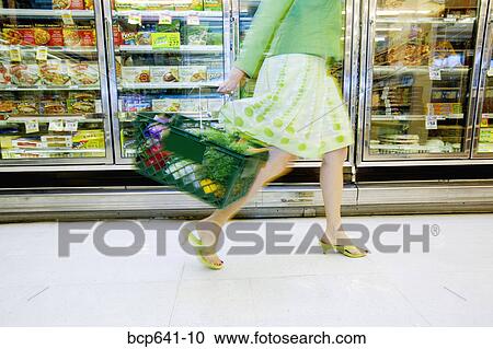 Stock Image - Woman shopping in supermarket. Fotosearch