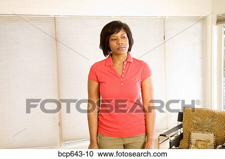Woman standing in living room View Large Photo Image Stock Image - Woman standing in living room. Fotosearch