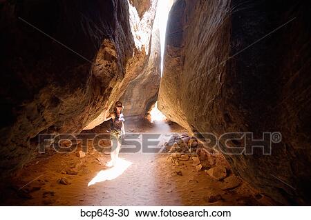 Woman standing under crevice in cave View Large Photo Image Stock Image - Woman standing under crevice in cave. Fotosearch