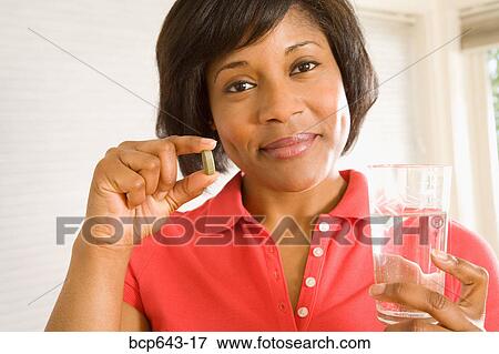 Woman taking a pill View Large Photo Image Stock Photo - Woman taking a pill. Fotosearch