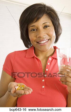 Woman taking handful of pills View Large Photo Image Stock Photograph - Woman taking handful of pills. Fotosearch