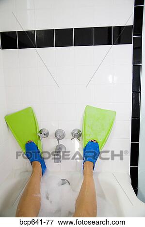 Stock Photo - Woman wearing flippers in bathtub. Fotosearch