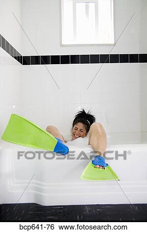 Stock Photograph - Woman wearing flippers in bathtub. Fotosearch
