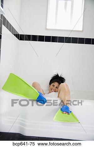 Stock Photography - Woman wearing flippers in bathtub. Fotosearch