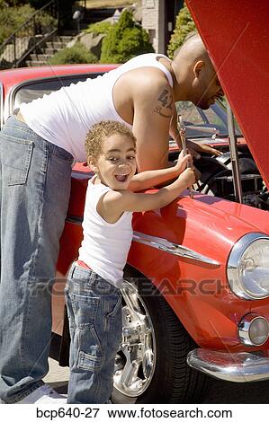 Stock Photo - Young boy holding tools for his mechanic father . Fotosearch