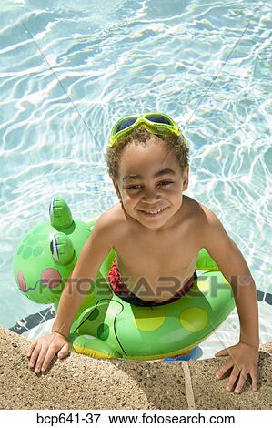 Young boy wearing a flotation device in pool View Large Photo Image Stock Photo - Young boy wearing a flotation device in pool. Fotosearch