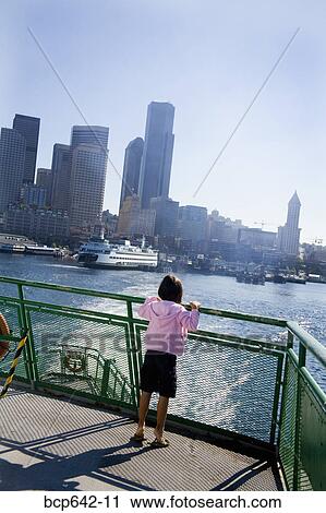 Young girl standing on dock overlooking city bay View Large Photo Image Stock Image - Young girl standing on dock overlooking city bay. Fotosearch