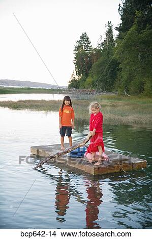 Young girls rowing on a raft in lake View Large Photo Image Picture - Young girls rowing on a raft in lake. Fotosearch