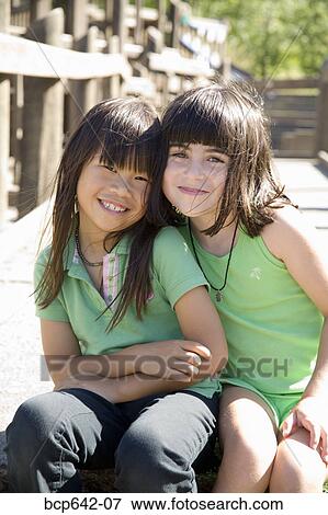 Young girls sitting together View Large Photo Image Stock Photo - Young girls sitting together. Fotosearch