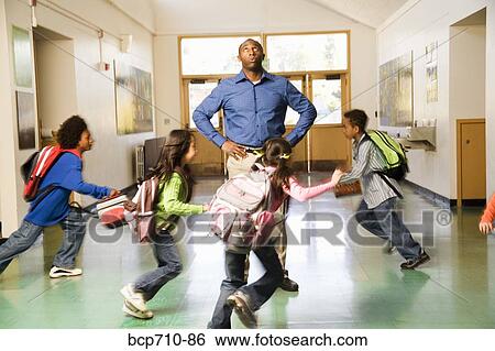 Blurred motion shot of students running past teacher View Large Photo Image Stock Photograph - Blurred motion shot of students running past teacher. Fotosearch