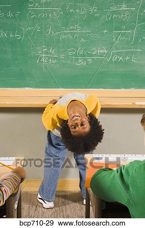 Boy bending over backward in front of blackboard View Large Photo Image Stock Photo - Boy bending over backward in front of blackboard. Fotosearch