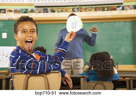 Boy holding drawing over teacher’s face View Large Photo Image Stock Image - Boy holding drawing over teacher’s face. Fotosearch