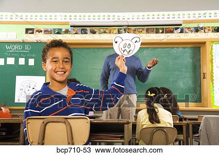 Boy holding drawing over teacher’s face View Large Photo Image Stock Image - Boy holding drawing over teacher’s face. Fotosearch
