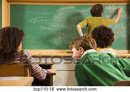Boy looking at girl’s paper in classroom View Large Photo Image Stock Photo - Boy looking at girl’s paper in classroom. Fotosearch