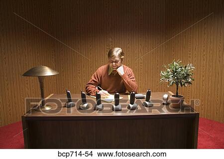 Businessman at desk with multiple telephones View Large Photo Image Picture - Businessman at desk with multiple telephones. Fotosearch