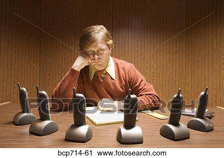 Businessman at desk with multiple telephones View Large Photo Image Stock Image - Businessman at desk with multiple telephones. Fotosearch