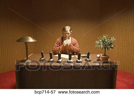 Businessman at desk with multiple telephones View Large Photo Image Stock Photo - Businessman at desk with multiple telephones. Fotosearch